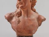 a brown bust of a woman with long hair on a clear base