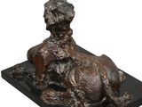 bronze sculpture of a dog laying down on a black base