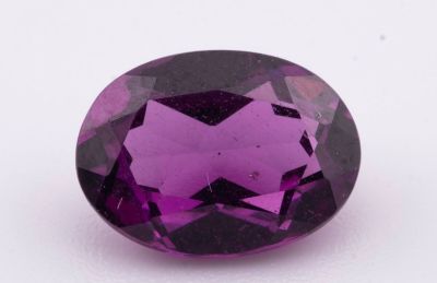 gros plan d'une pierre précieuse violette sur une surface blanche