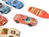 several toy cars are lined up in a row on a white surface