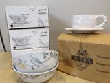 three bowls and a cup sitting on a table next to a box