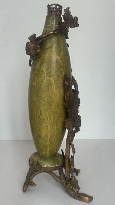 un vase vert posé sur un socle