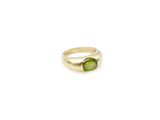 a close up of a ring with a green stone on it