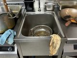 stainless steel kitchen sink with pots and pans on top of it