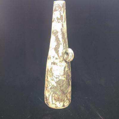 un vase blanc orné d'un motif posé sur une surface noire