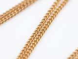 a close up of a gold chain on a white surface