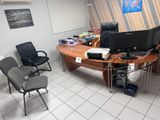 un bureau avec deux écrans d'ordinateur et deux chaises dans la pièce