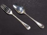 two silver spoons and a fork on a table