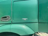 a green semi truck parked on the side of the road