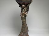 bronze statue of a woman holding a bowl on her head