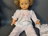 a doll that is laying on the ground next to a pair of shoes