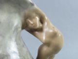 a statue of a man sitting on top of a vase
