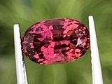 une image représentant un diamant rose tenu par une pince