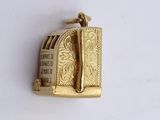 a gold plated brooch with a picture of a toaster on it