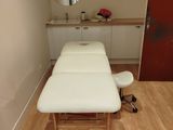 une table de massage dans une pièce où il y a un miroir accroché au mur