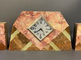 a clock sitting on top of a table next to two vases
