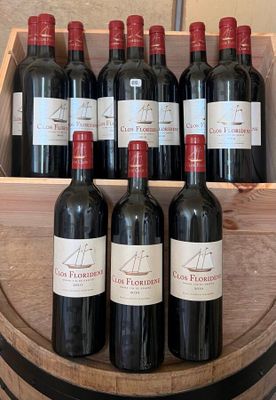 plusieurs bouteilles de vin rouge dans une caisse en bois posée sur un tonneau