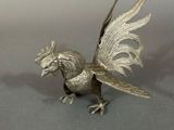 a silver colored bird figurine on a table