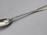 silver spoon on a white surface with a small spoon in the middle of it