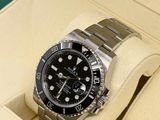 a rolex watch in a box on a white surface