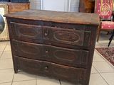 une commode en bois dans une pièce où se trouve un tapis