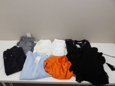 une table blanche sur laquelle sont posés un tas de vêtements