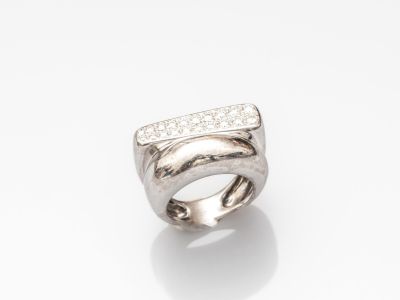 gros plan d'une bague avec des diamants sur une surface blanche