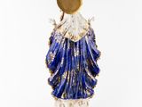 a blue and white statue of a woman holding a gold disc