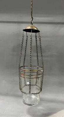a glass hanging from the ceiling with a chain around it