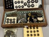 une boîte en bois contenant des boutons et d'autres objets