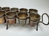 six cups on a rack with handles on a white surface