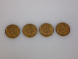 three gold coins are shown in a row on a white surface