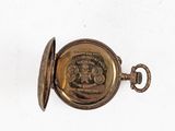 a gold pocket watch with a picture of a lion on it