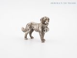 silver figurine of a dog with a collar on a white background