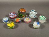 six glass marbles with different designs on them sitting on a table