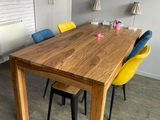 une table en bois entourée de quatre chaises dans une pièce
