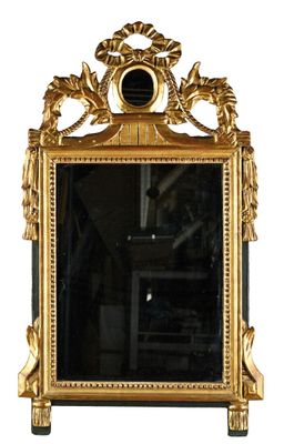 un miroir avec un cadre doré et une horloge dessus