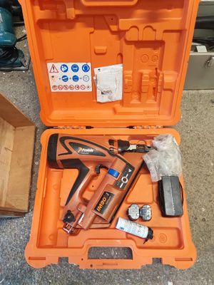 une mallette à outils orange contenant une agrafeuse et un pistolet à clous