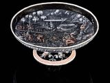 une assiette ancienne en argent avec un fond noir et un fond noir