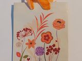 une photo d'un sac en papier orné de fleurs