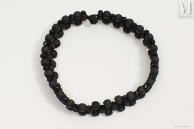 un bracelet composé de perles de lave noires sur un fond blanc