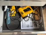 a tool in the drawer of a kitchen that is being used