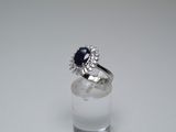 an image of a ring with a blue stone on top of a clear glass