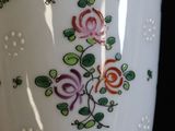 a vase with flowers painted on it sitting on a table