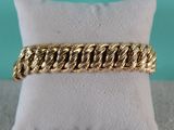 a gold bracelet on a pillow with a pillow in the background