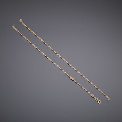 a pair of gold chain bracelets on a grey background