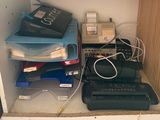 a computer and printer sitting on a shelf in a closet