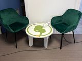 deux chaises vertes et une petite table dans une pièce