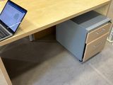 a laptop sitting on a wooden desk in a room