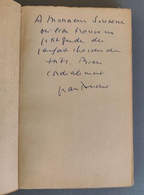 un livre ouvert, sur lequel est inscrit un poème écrit à la main, posé sur une table